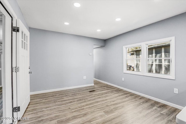 spare room with recessed lighting, baseboards, visible vents, and wood finished floors