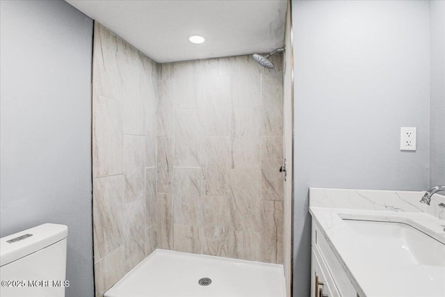 bathroom featuring vanity, a stall shower, and toilet