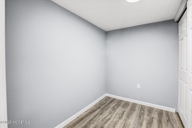 empty room featuring baseboards and wood finished floors