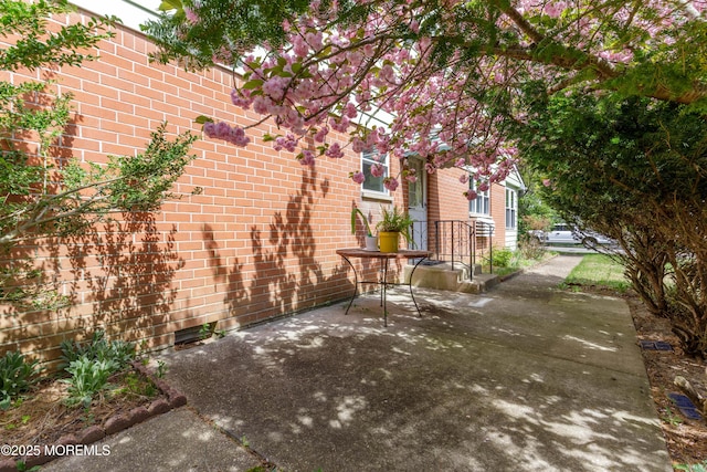 view of home's exterior featuring brick siding and a patio area