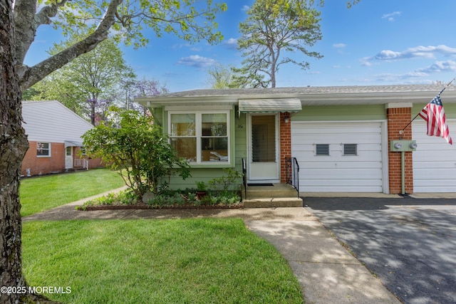 view of front of house featuring a garage, driveway, a front lawn, and brick siding