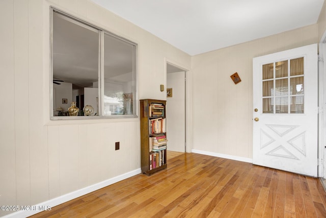 interior space featuring baseboards and light wood finished floors