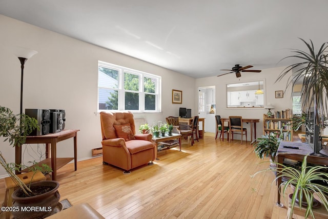 living area with ceiling fan and light wood-style flooring