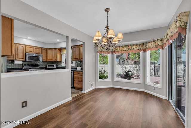 5 Beth Dr, Middletown, NJ 07748 - kitchen with an inviting chandelier, decorative backsplash, dark wood-style flooring, baseboards, and appliances with stainless steel finishes
