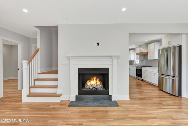 26 Rumson Pl, Little Silver, NJ 07739 - unfurnished living room with baseboards, stairway, light wood-type flooring, recessed lighting, and a fireplace with flush hearth