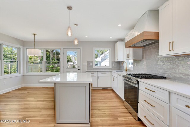 26 Rumson Pl, Little Silver, NJ 07739 - kitchen with custom exhaust hood, a kitchen island, light wood-type flooring, tasteful backsplash, and stainless steel range with gas stovetop