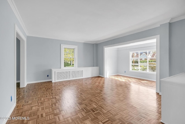 empty room featuring crown molding and baseboards