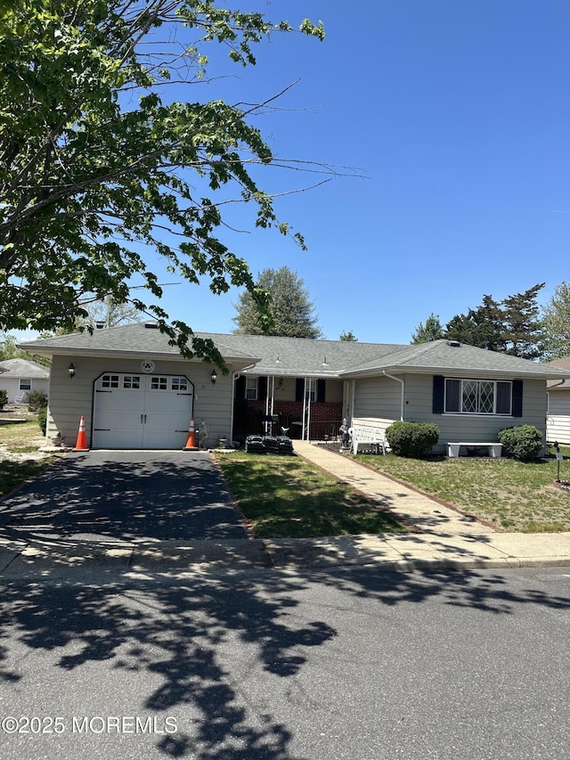 single story home with an attached garage and aphalt driveway