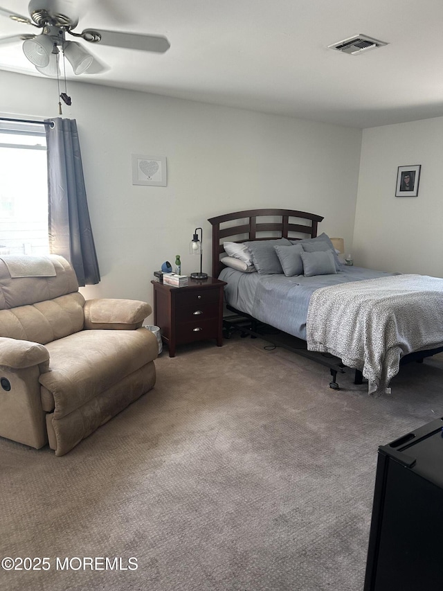 bedroom with carpet floors, a ceiling fan, and visible vents