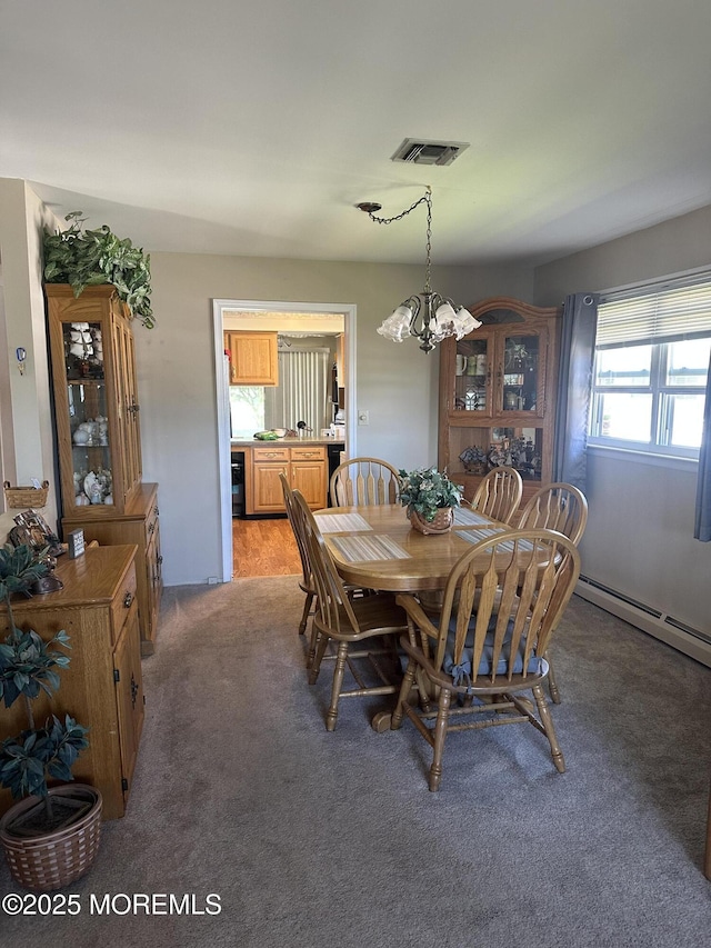 dining area featuring light colored carpet, a chandelier, a baseboard heating unit, and visible vents
