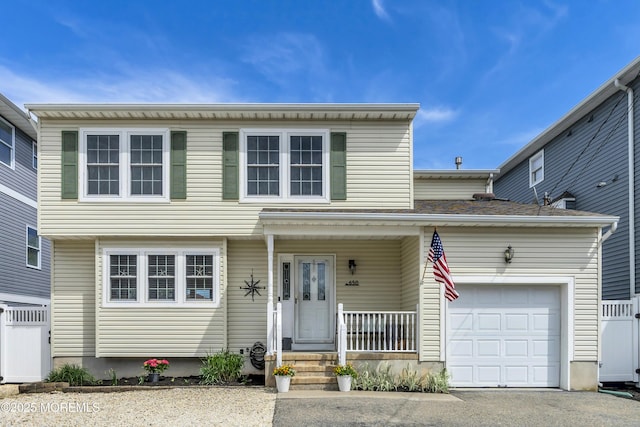 view of front of home with an attached garage, aphalt driveway, and covered porch