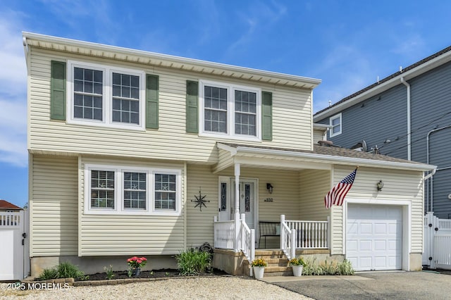 view of front of property with an attached garage, a porch, and aphalt driveway