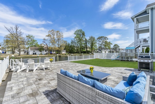 view of patio with fence, an outdoor hangout area, grilling area, a water view, and a playground