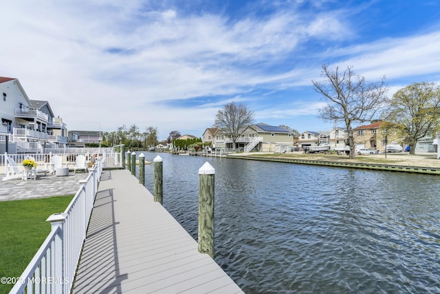 view of dock with a water view and a residential view