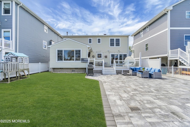 rear view of house featuring fence, a deck, outdoor lounge area, a patio area, and a yard