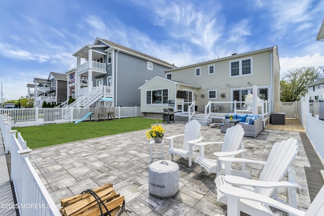 rear view of house with a yard, outdoor lounge area, a fenced backyard, and a patio area