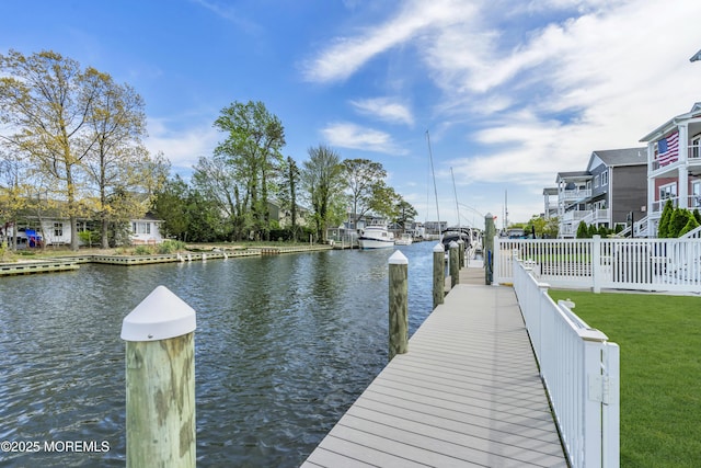 dock area with a lawn and a water view