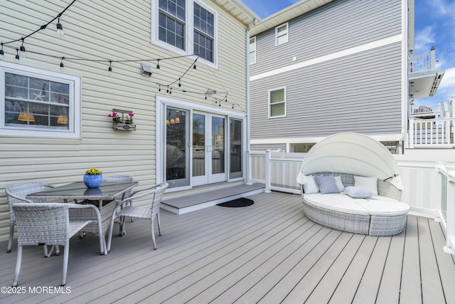 deck with french doors and outdoor dining area