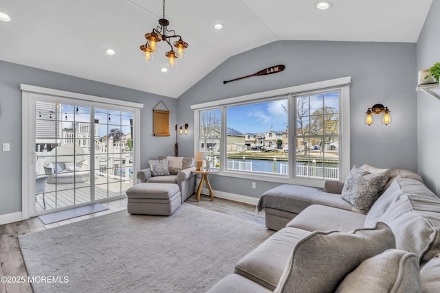 living room featuring wood finished floors, baseboards, a water view, a chandelier, and vaulted ceiling