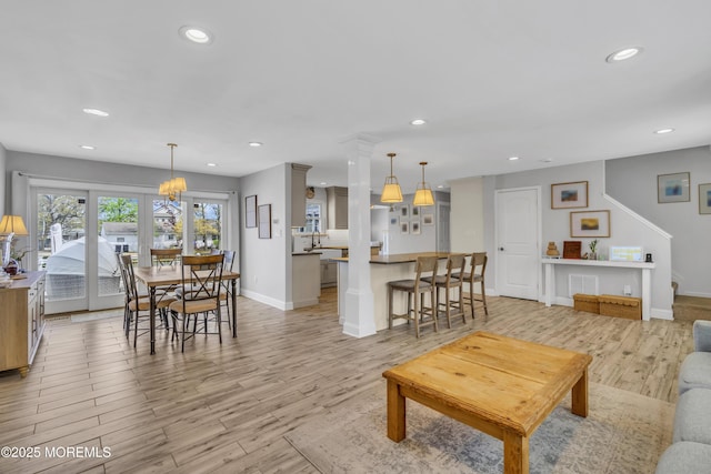 living room featuring baseboards, recessed lighting, and light wood-style flooring