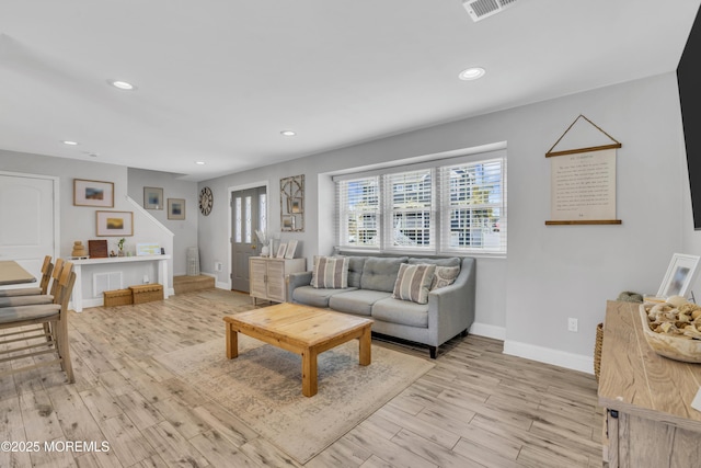 living area featuring a healthy amount of sunlight, baseboards, light wood-type flooring, and recessed lighting