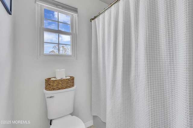 full bath with toilet and a shower with shower curtain