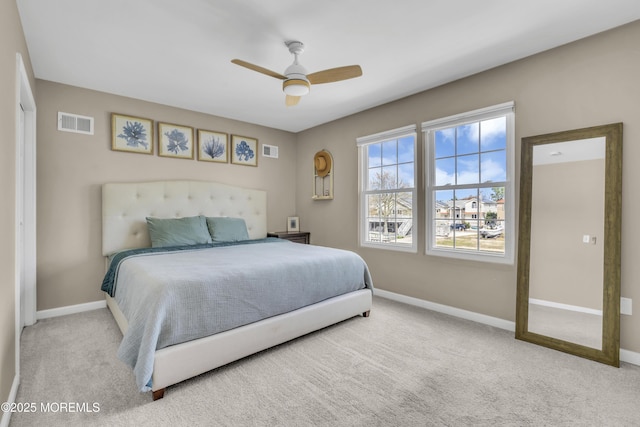 carpeted bedroom with visible vents, a ceiling fan, and baseboards