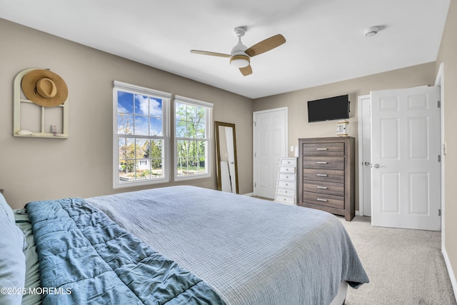 bedroom with a ceiling fan and light colored carpet