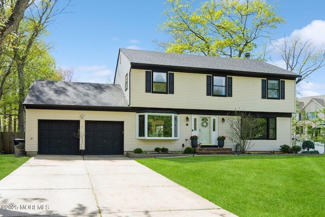colonial house with roof with shingles, driveway, a front yard, and a garage