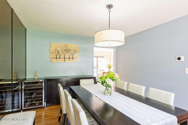 dining space featuring wood finished floors and wine cooler
