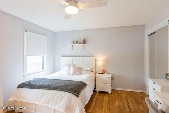 bedroom featuring baseboards, ceiling fan, a closet, and wood finished floors
