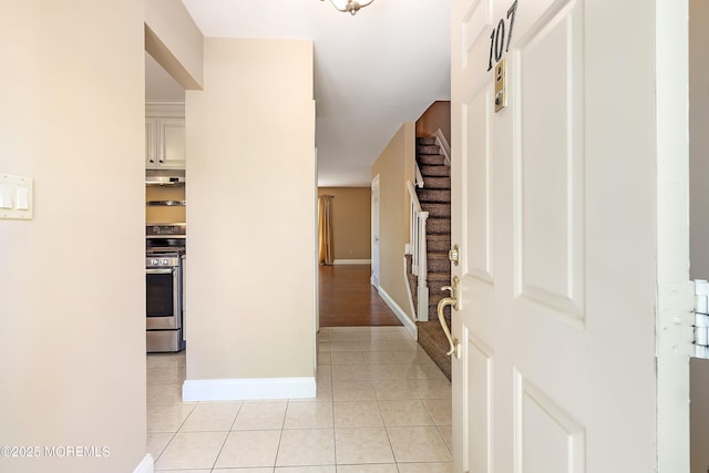 entrance foyer featuring baseboards, stairway, and light tile patterned flooring