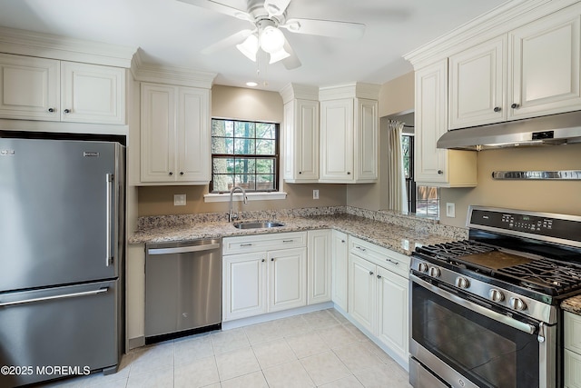 kitchen featuring a sink, light stone countertops, ceiling fan, under cabinet range hood, and appliances with stainless steel finishes