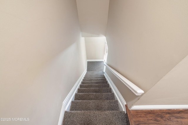 staircase with baseboards and carpet floors