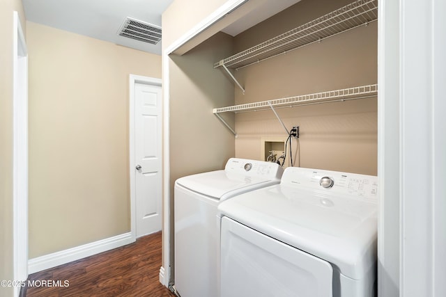 clothes washing area featuring washer and dryer, dark wood-type flooring, baseboards, and visible vents