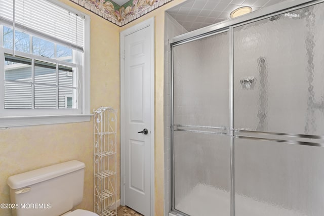 full bath featuring a shower stall and toilet