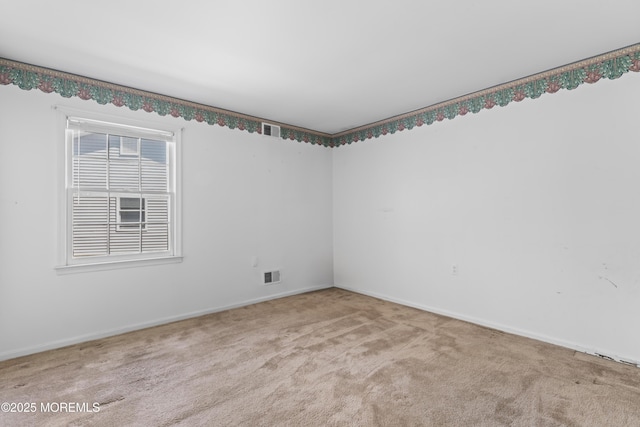 unfurnished room with carpet floors, baseboards, and visible vents