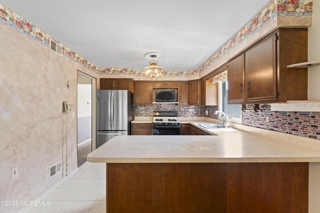 kitchen with light countertops, stainless steel appliances, visible vents, and a sink