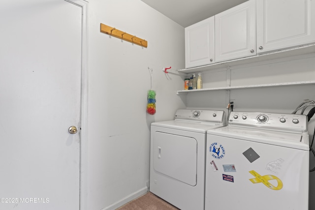 washroom featuring baseboards, cabinet space, and washer and clothes dryer