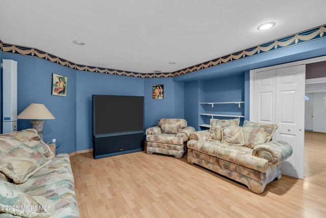 living room with built in features, baseboards, recessed lighting, and wood finished floors