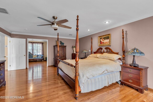 bedroom featuring light wood-style floors, ornamental molding, and visible vents