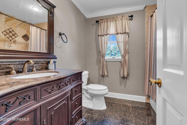 bathroom with baseboards, ornamental molding, vanity, and toilet