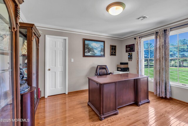 home office with baseboards, plenty of natural light, light wood finished floors, and visible vents
