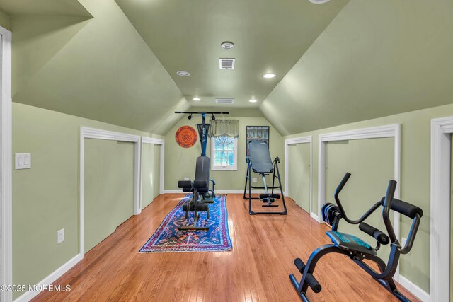 workout area with baseboards, recessed lighting, wood finished floors, and vaulted ceiling