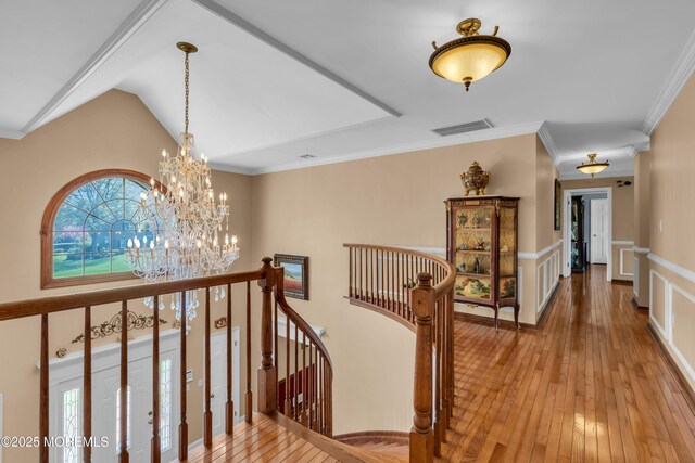 hallway featuring a notable chandelier, visible vents, an upstairs landing, and light wood-type flooring