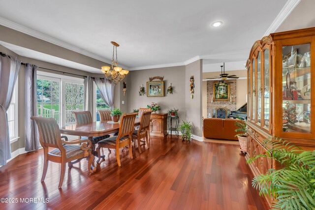dining area featuring crown molding, baseboards, and wood finished floors