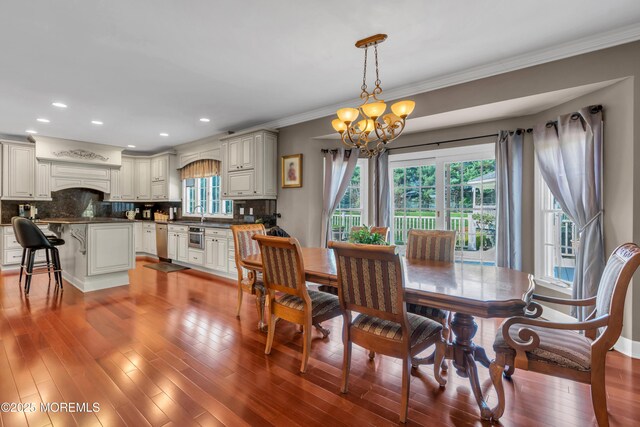 dining area featuring recessed lighting, ornamental molding, light wood-type flooring, and a chandelier