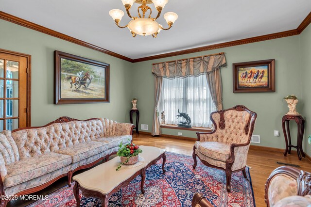 living area featuring a notable chandelier, a healthy amount of sunlight, and wood finished floors