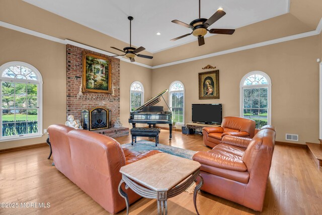 living room with plenty of natural light, a fireplace, light wood-style flooring, and visible vents