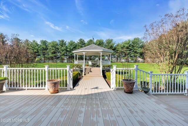 wooden terrace with a gazebo and a yard